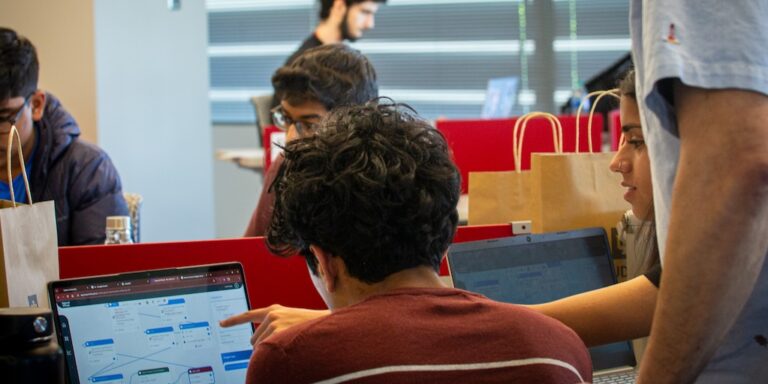 Students work on chatbot architecture on computer screen at AI Botathon