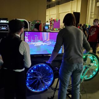 MagFest 2024 attendees play Frameshifters game using bicycle wheels as controllers