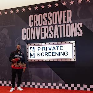 Juwann Nelson poses next to Crossover Conversations sign at NBA All Star Weekend premier
