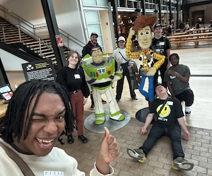 MAS students at Pixar Studios with models of Woody and Buzz from Toy Story